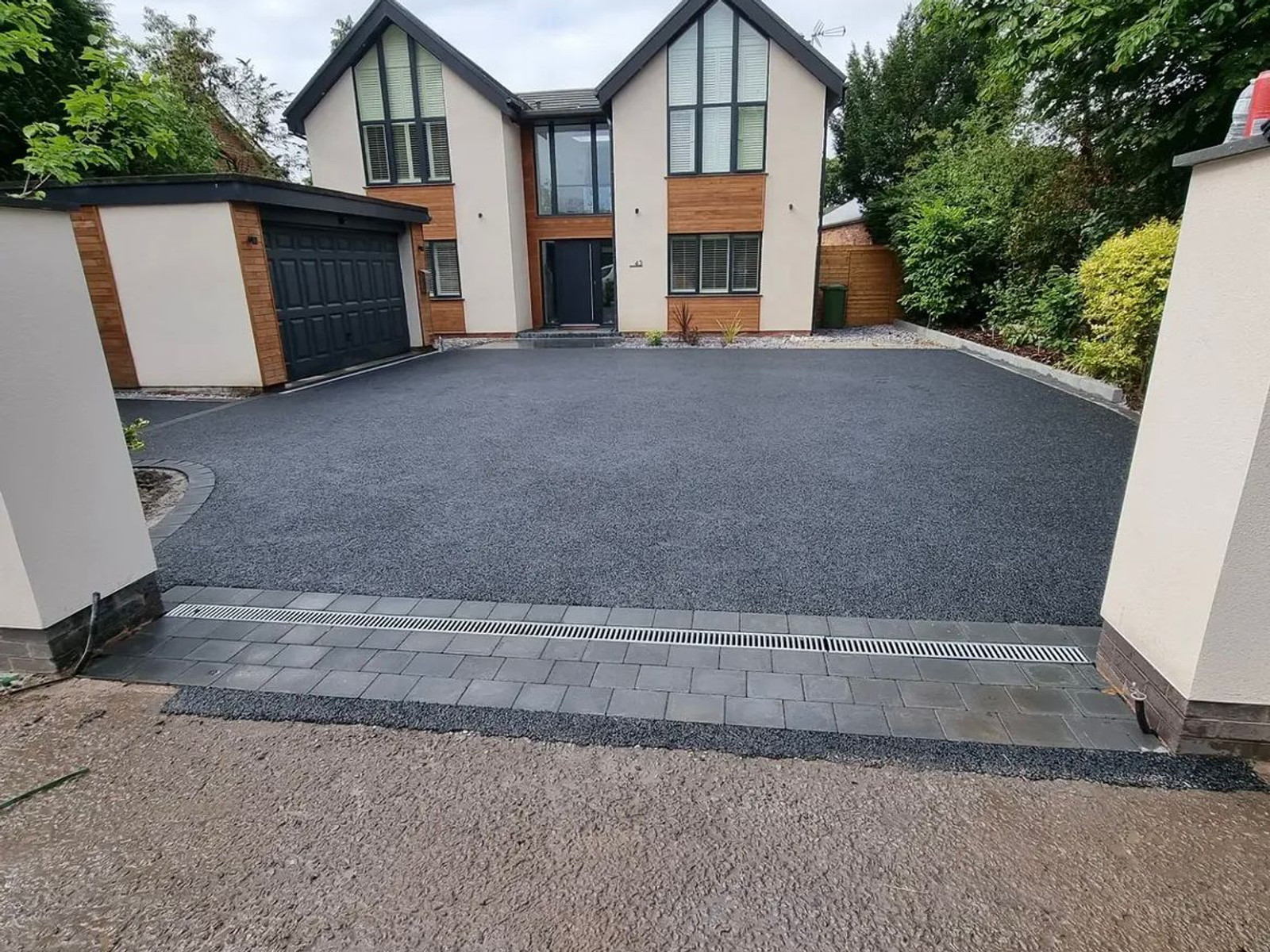 Dark charcoal driveway with neat edging at a modern home